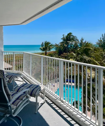 a view of a balcony with wooden floor and outdoor seating