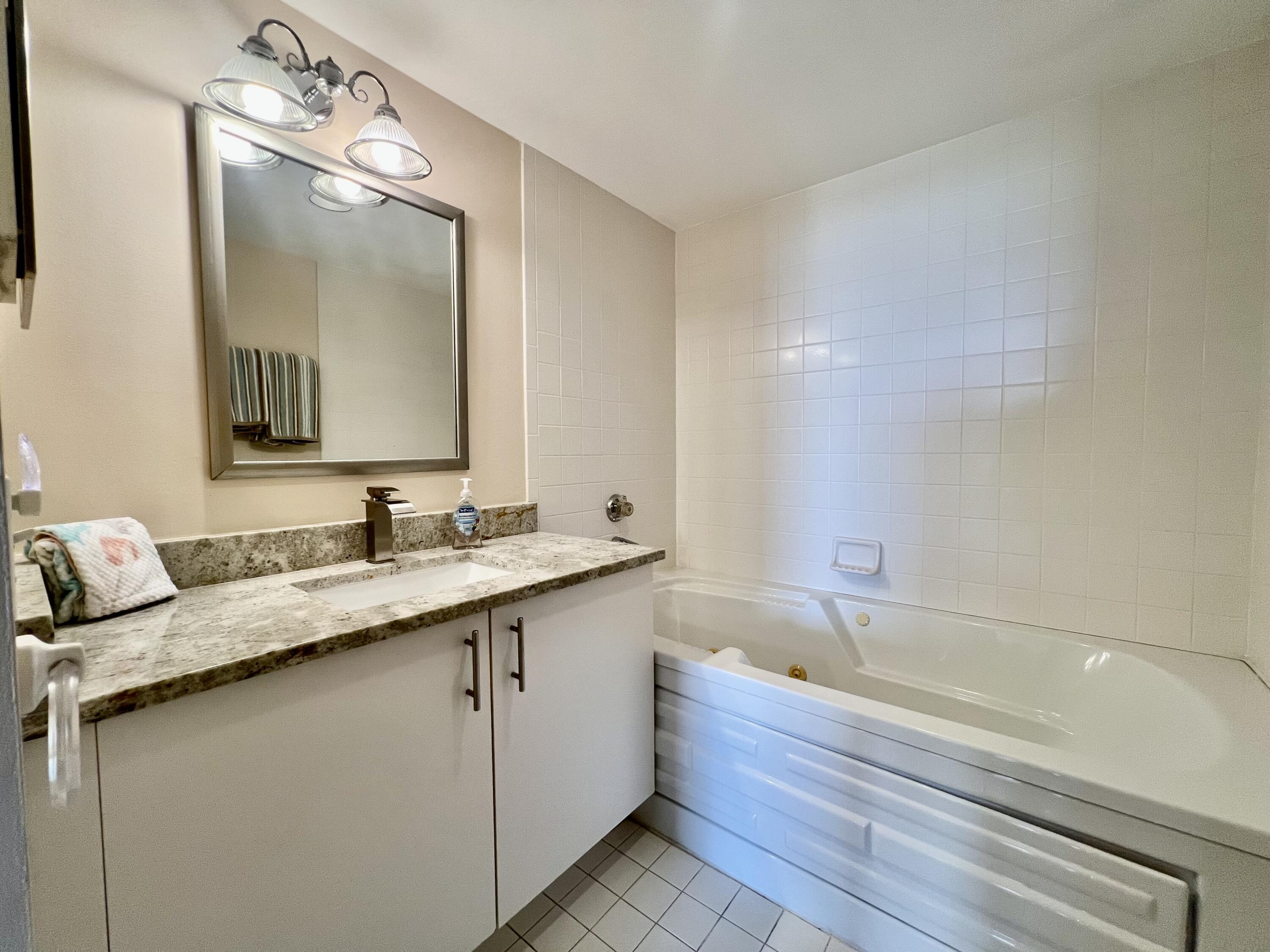 2700 North Hwy A1A, Unit 506 Fort Pierce, FL 34949 - Photo 17 of 28 a bathroom with a tub sink and mirror