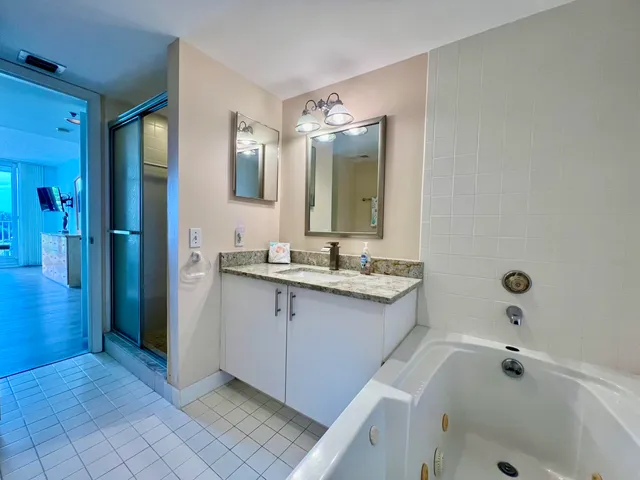 a bathroom with a tub sink and mirror