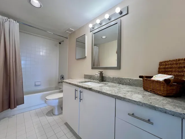 a bathroom with a granite countertop sink mirror and toilet