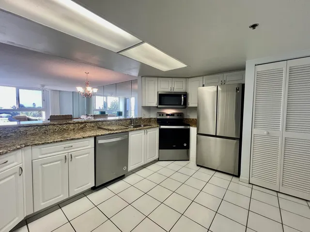 a kitchen with stainless steel appliances granite countertop a refrigerator sink and stove