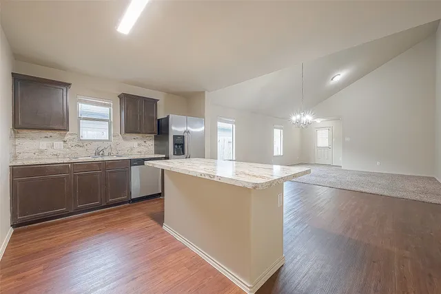 a kitchen with a sink a microwave and cabinets
