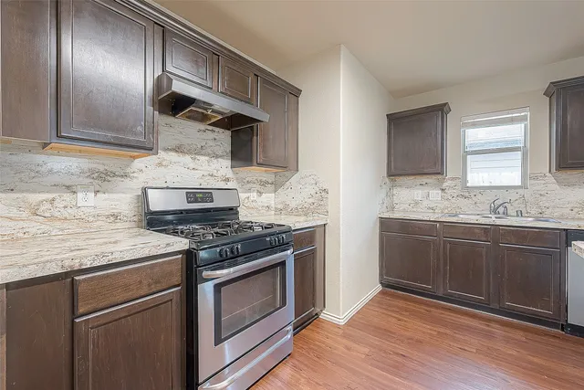 a stove top oven sitting inside of a kitchen