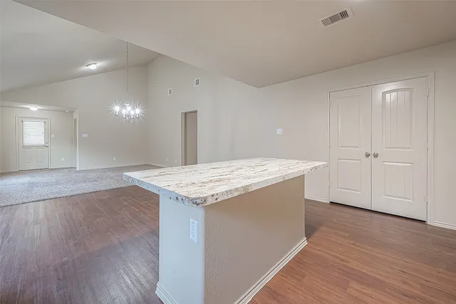 a kitchen with stainless steel appliances granite countertop a refrigerator a sink and wooden cabinets