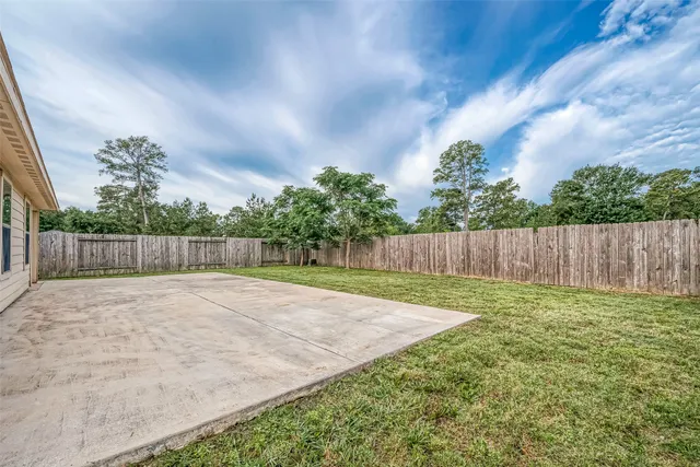 a view of backyard with wooden fence