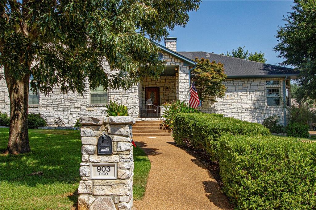 a front view of a house with a garden and patio