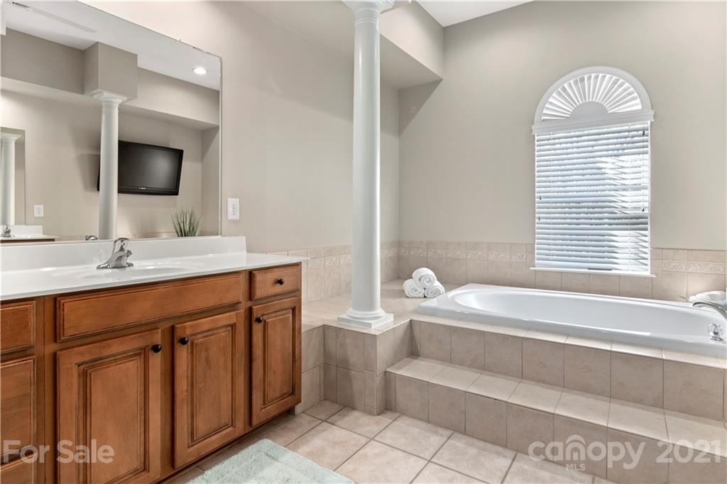 1933 Faison Avenue, Unit 69 Fort Mill, SC 29708 - Photo 20 of 40 a spacious bathroom with a bathtub sink and a mirror