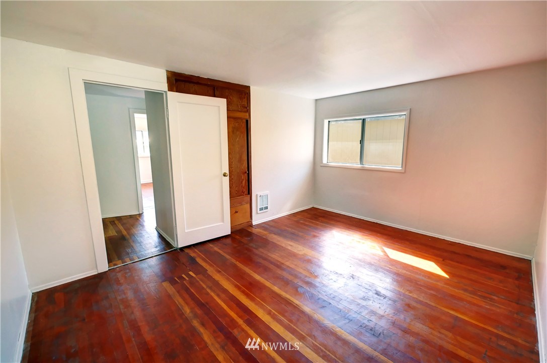 628 Twisp Carlton Road Twisp, WA 98856 - Photo 13 of 32 an empty room with wooden floor and windows