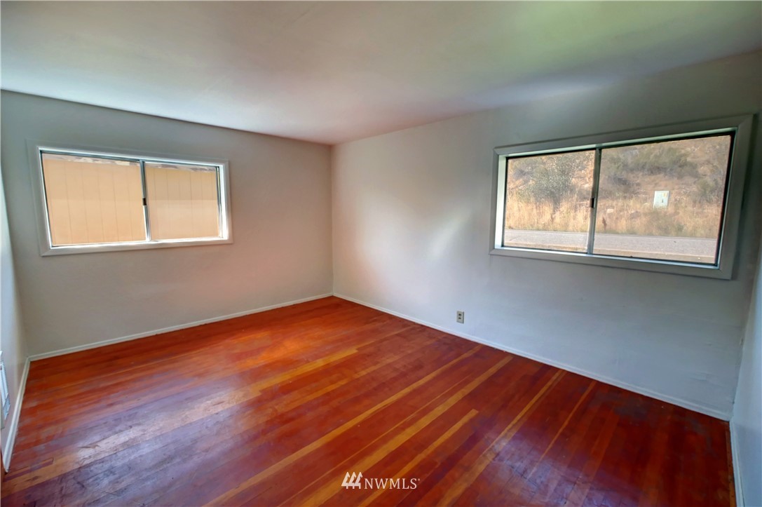 628 Twisp Carlton Road Twisp, WA 98856 - Photo 14 of 32 an empty room with wooden floor and windows