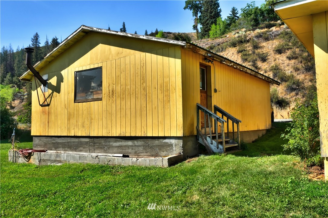 628 Twisp Carlton Road Twisp, WA 98856 - Photo 27 of 32 a view of a small house with yard and sitting area