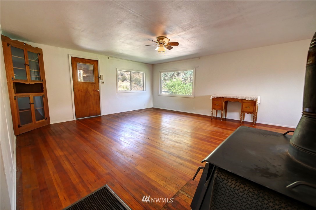 628 Twisp Carlton Road Twisp, WA 98856 - Photo 5 of 32 a view of an empty room with wooden floor and a window