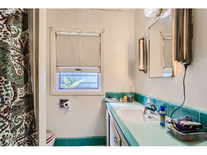 11 Northeast 62nd Avenue Portland, OR 97213 - Photo 21 of 28 a bathroom with a sink a mirror and a shower