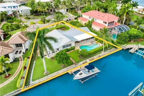 an aerial view of a residential houses with yard