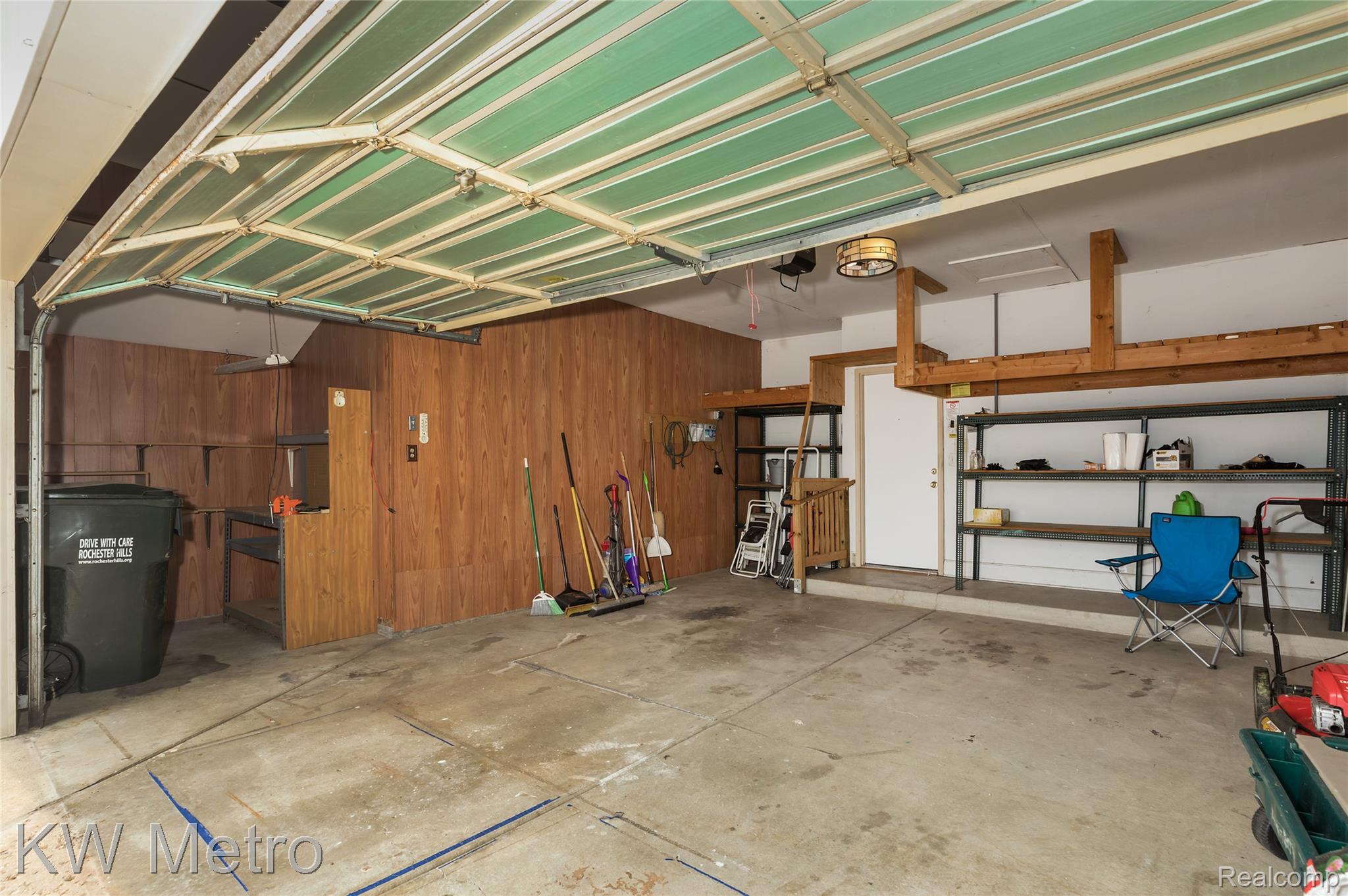 2154 Warrington Road Rochester, MI 48307 - Photo 30 of 41 Two-car garage featuring a concrete floor, overhead storage shelving, wood paneling, and an interior access door