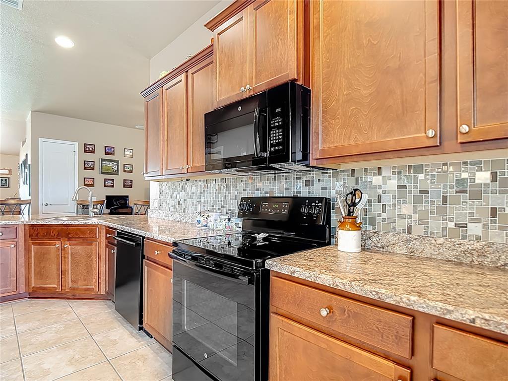 1170 Legatto Loop Dundee, FL 33838 - Photo 15 of 38 a kitchen with stainless steel appliances granite countertop a stove a sink and a microwave