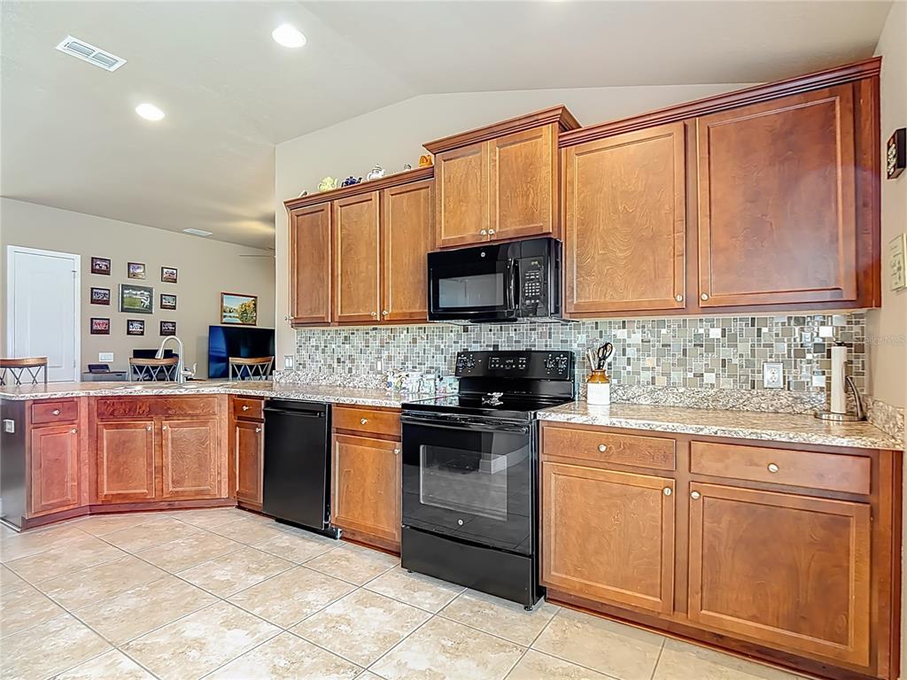 1170 Legatto Loop Dundee, FL 33838 - Photo 16 of 38 a kitchen with stainless steel appliances granite countertop a stove top oven a sink dishwasher and a microwave oven on the blue kitchen countertops