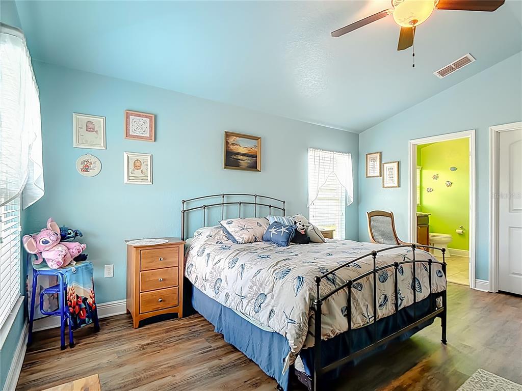 1170 Legatto Loop Dundee, FL 33838 - Photo 21 of 38 a bedroom with a bed and a chandelier