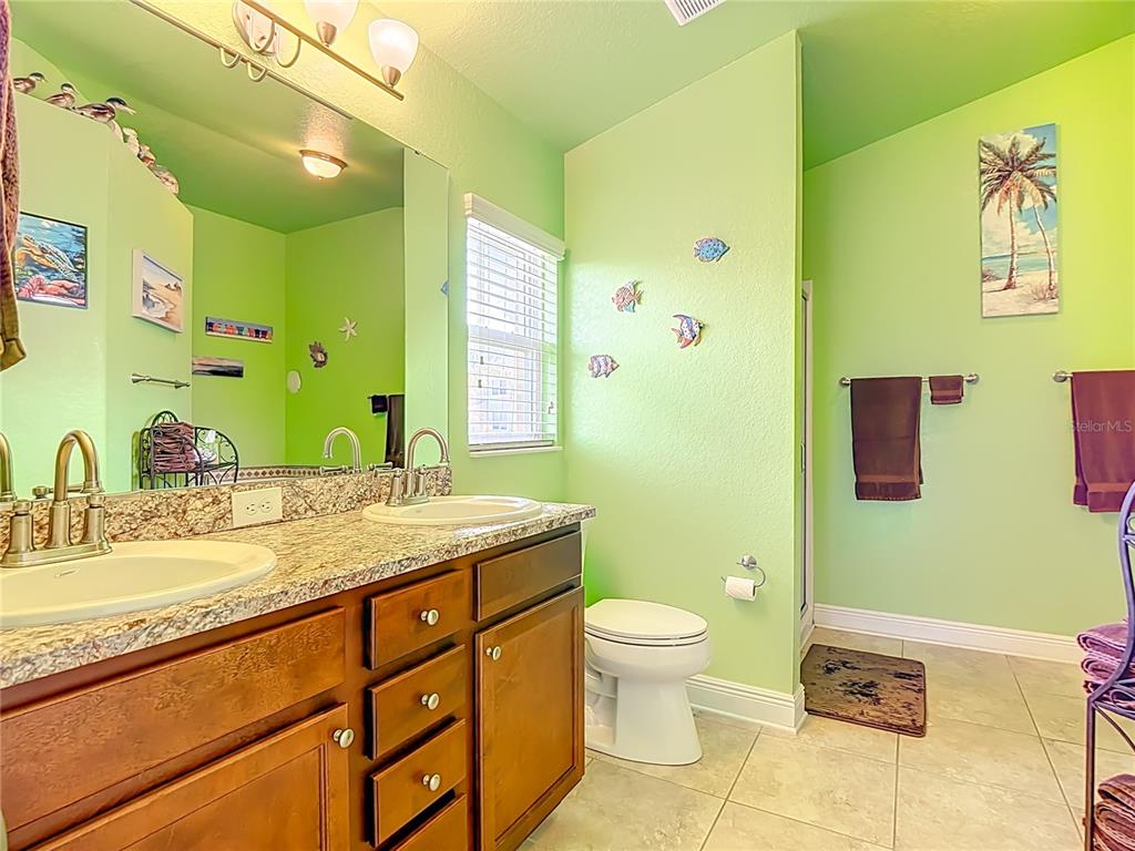 1170 Legatto Loop Dundee, FL 33838 - Photo 22 of 38 a bathroom with a granite countertop toilet sink and mirror