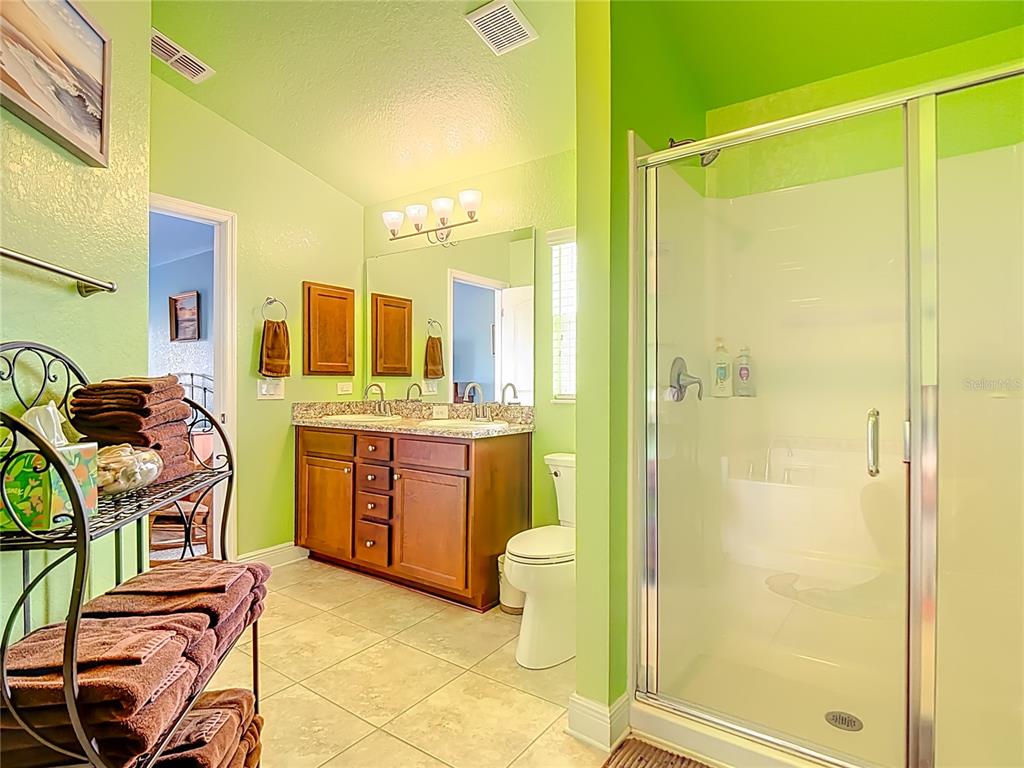 1170 Legatto Loop Dundee, FL 33838 - Photo 24 of 38 a bathroom with a granite countertop sink mirror vanity and toilet