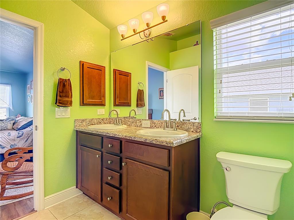 1170 Legatto Loop Dundee, FL 33838 - Photo 25 of 38 a bathroom with a granite countertop toilet sink and mirror