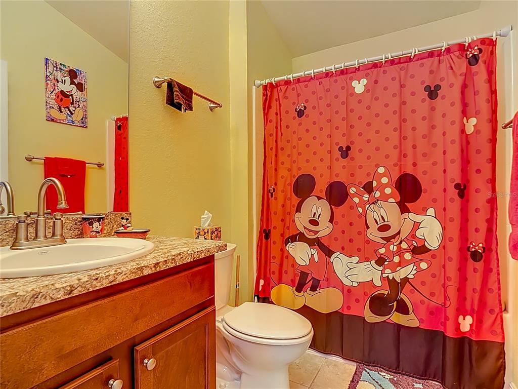 1170 Legatto Loop Dundee, FL 33838 - Photo 28 of 38 a bathroom with a granite countertop toilet sink and mirror