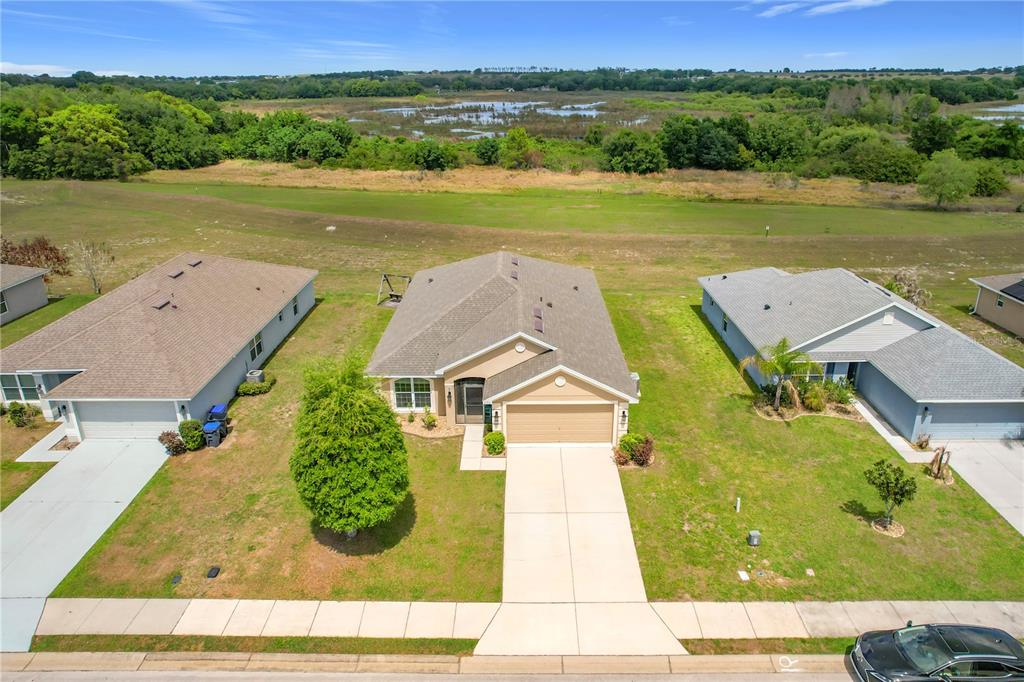 1170 Legatto Loop Dundee, FL 33838 - Photo 3 of 38 an aerial view of a house with a garden and lake view