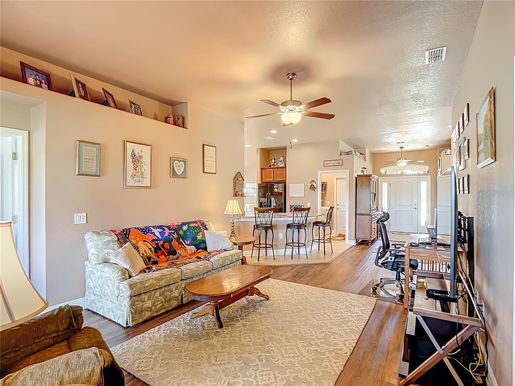 1170 Legatto Loop Dundee, FL 33838 - Photo 6 of 38 a living room with furniture a rug and a chandelier