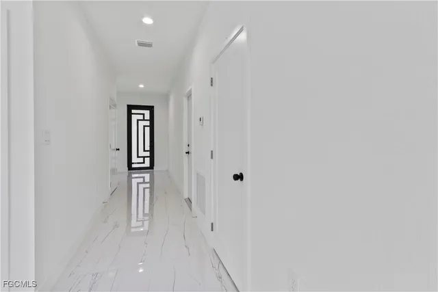 a large white kitchen with kitchen island a sink a stove and a refrigerator