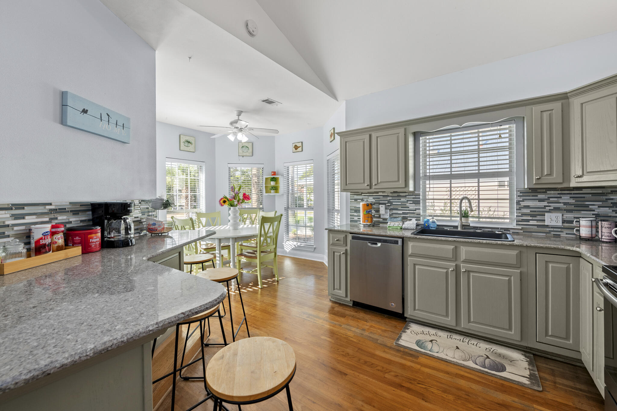 4431 Luke Avenue Destin, FL 32541 - Photo 12 of 100 a kitchen with stainless steel appliances granite countertop a kitchen island hardwood floor sink stove dining table and chairs