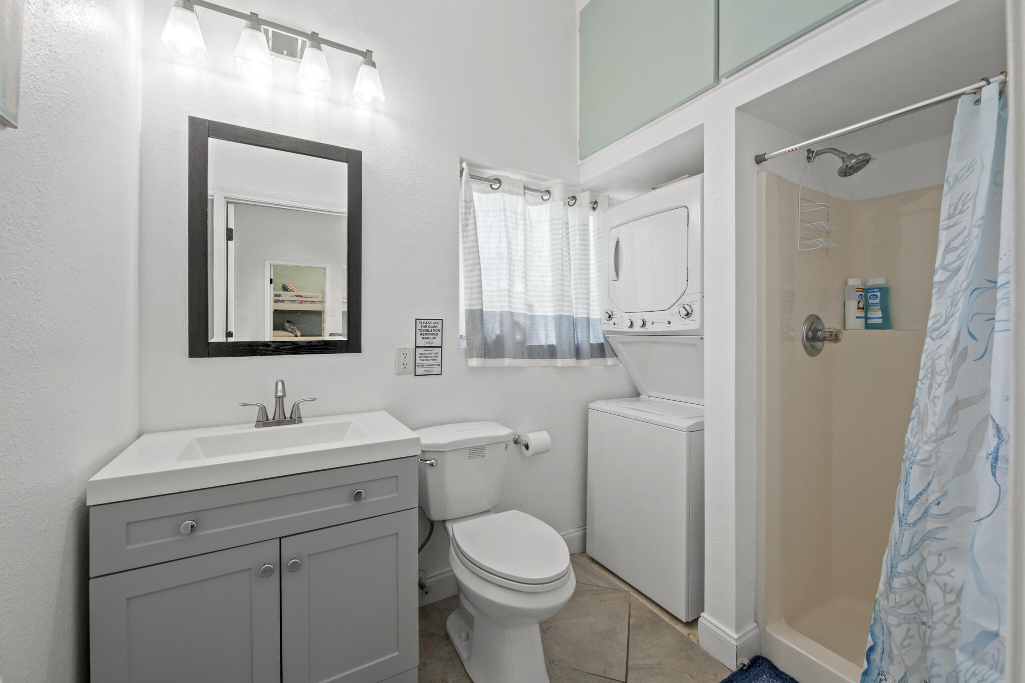 4431 Luke Avenue Destin, FL 32541 - Photo 90 of 100 a bathroom with a toilet sink vanity and mirror