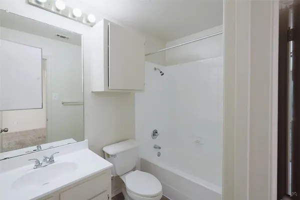 a bathroom with a sink a light fixture and a toilet
