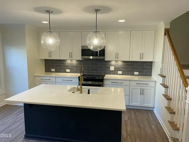 a kitchen with kitchen island a sink stainless steel appliances and cabinets