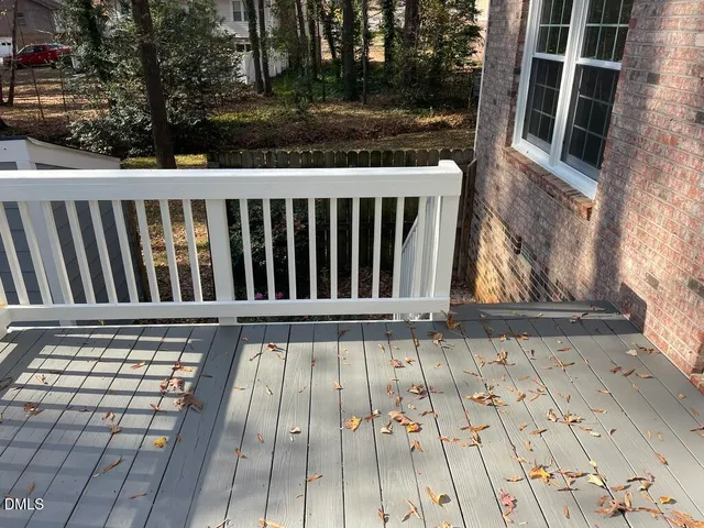 a view of a balcony with wooden floor and fence
