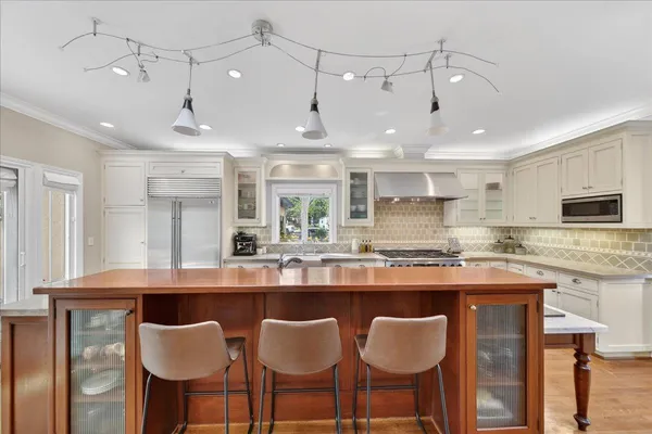 a kitchen with kitchen island stainless steel appliances a sink and cabinets