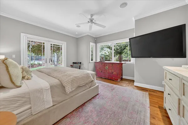 a bedroom with a large bed and wooden floor