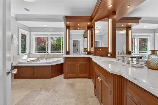 a bathroom with a granite countertop sink a mirror and a bathtub