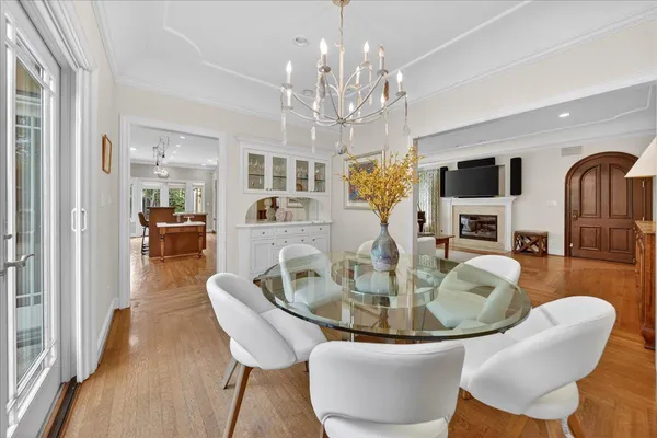 a dining room with furniture a chandelier and wooden floor