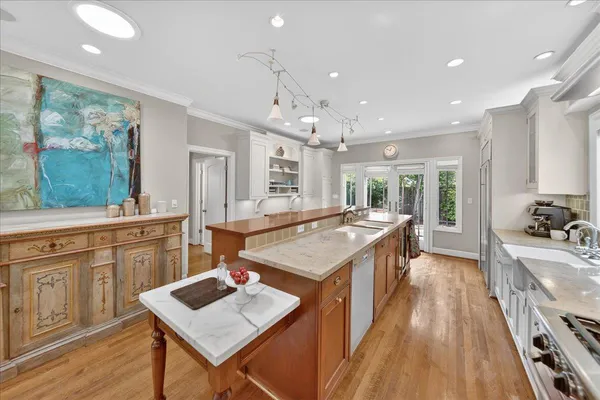 a large kitchen with kitchen island a large island in white appliances