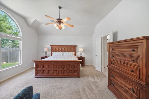 a bedroom with furniture and a chandelier fan