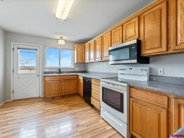 a kitchen with stainless steel appliances granite countertop a stove sink microwave and refrigerator
