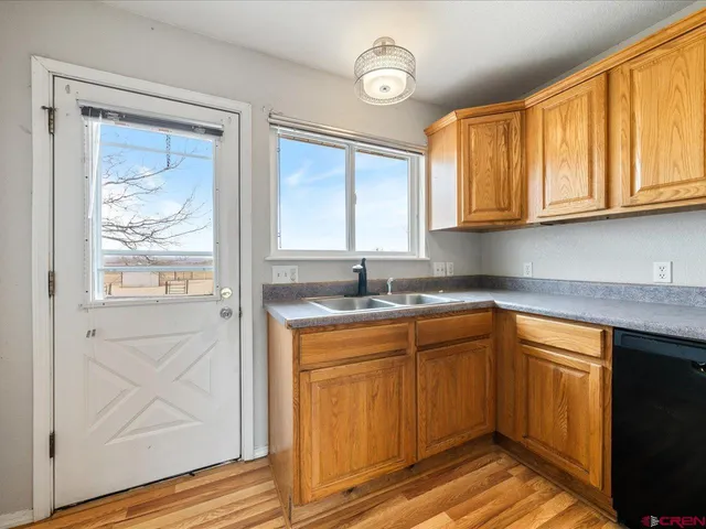 a kitchen with stainless steel appliances granite countertop a sink and cabinets with wooden floor