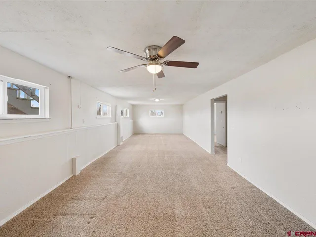a view of a livingroom with a ceiling fan and window