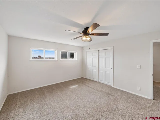 a view of an empty room with a ceiling fan