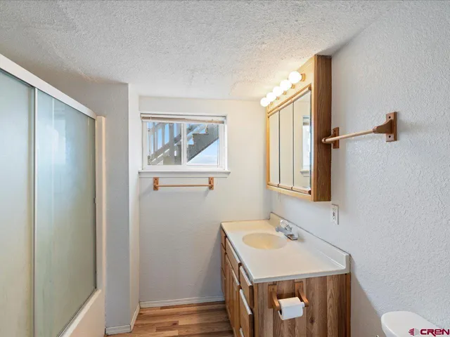 a bathroom with a sink a toilet and mirror