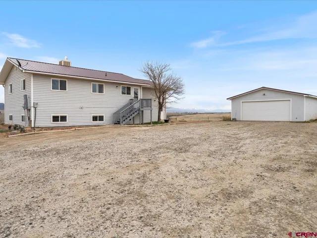 a view of a house with backyard and tree