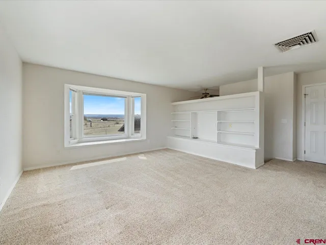 an empty room with a cabinet and mirrors