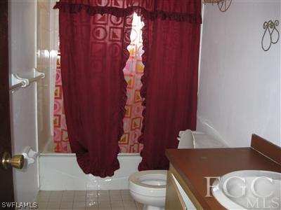 9065 Hamlin Road West Fort Myers, FL 33967 - Photo 3 of 5 a bathroom with a toilet and shower curtain