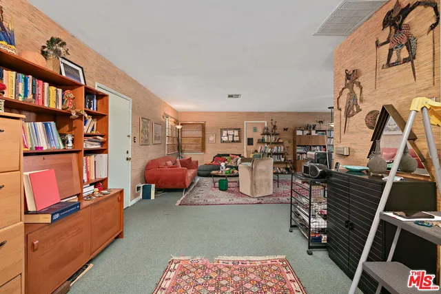 a living room with furniture and a book shelf