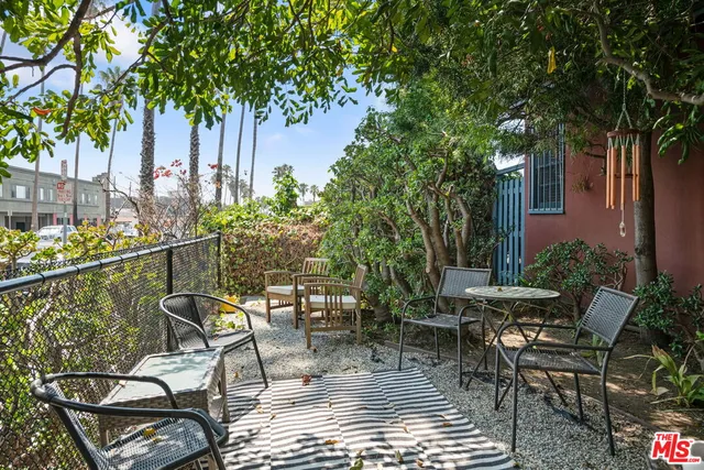 a patio with table and chairs and potted plants