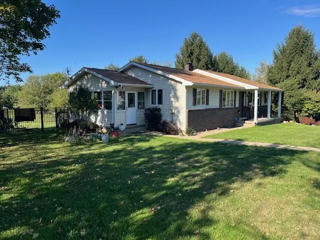 a view of a house with a yard and sitting area